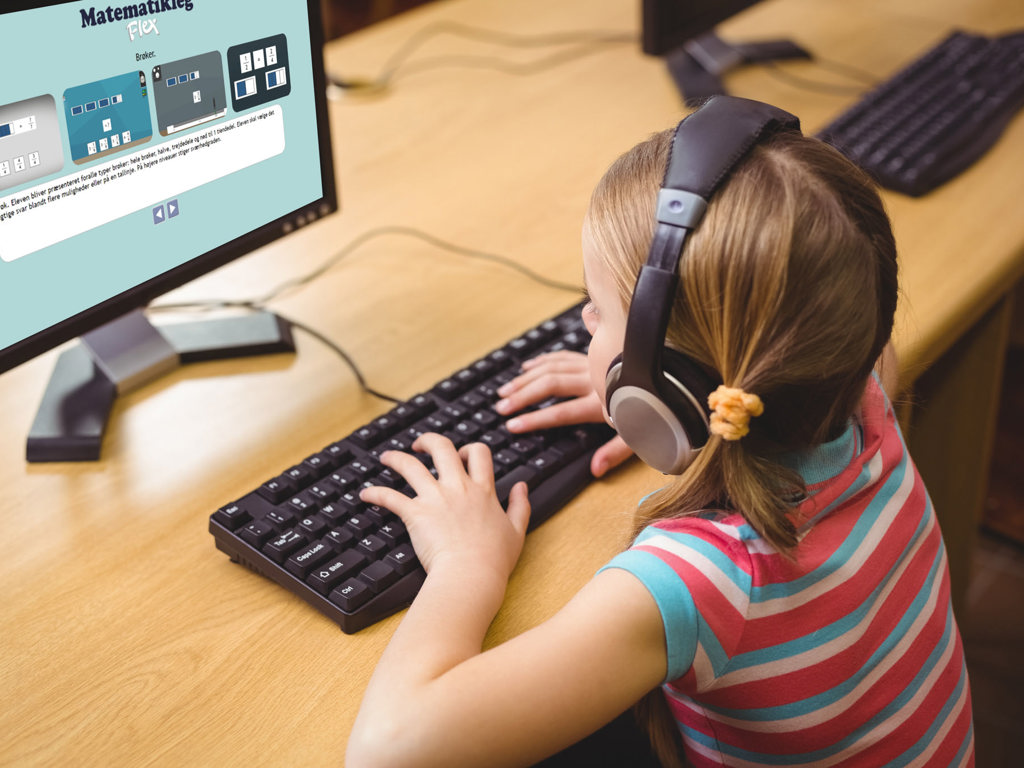 Pige sidder ved en computer og træner matematikopgaver 