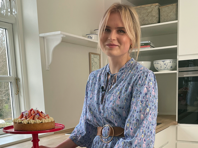 Johanne Gormsen står i et køkken med en frisklavet jordbærtærte