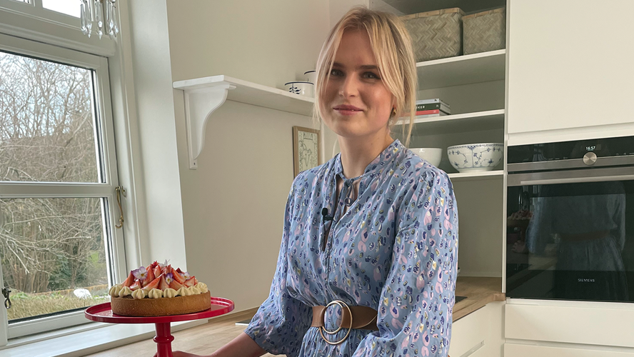 Johanne Gormsen står i et køkken med en frisklavet jordbærtærte