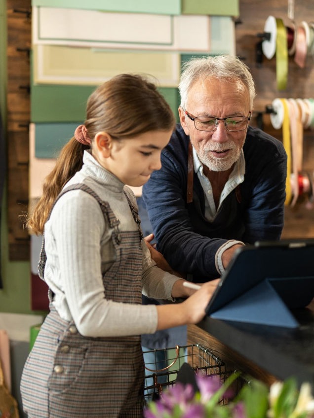 Bedstefar og barnebarn kigger på en tablet